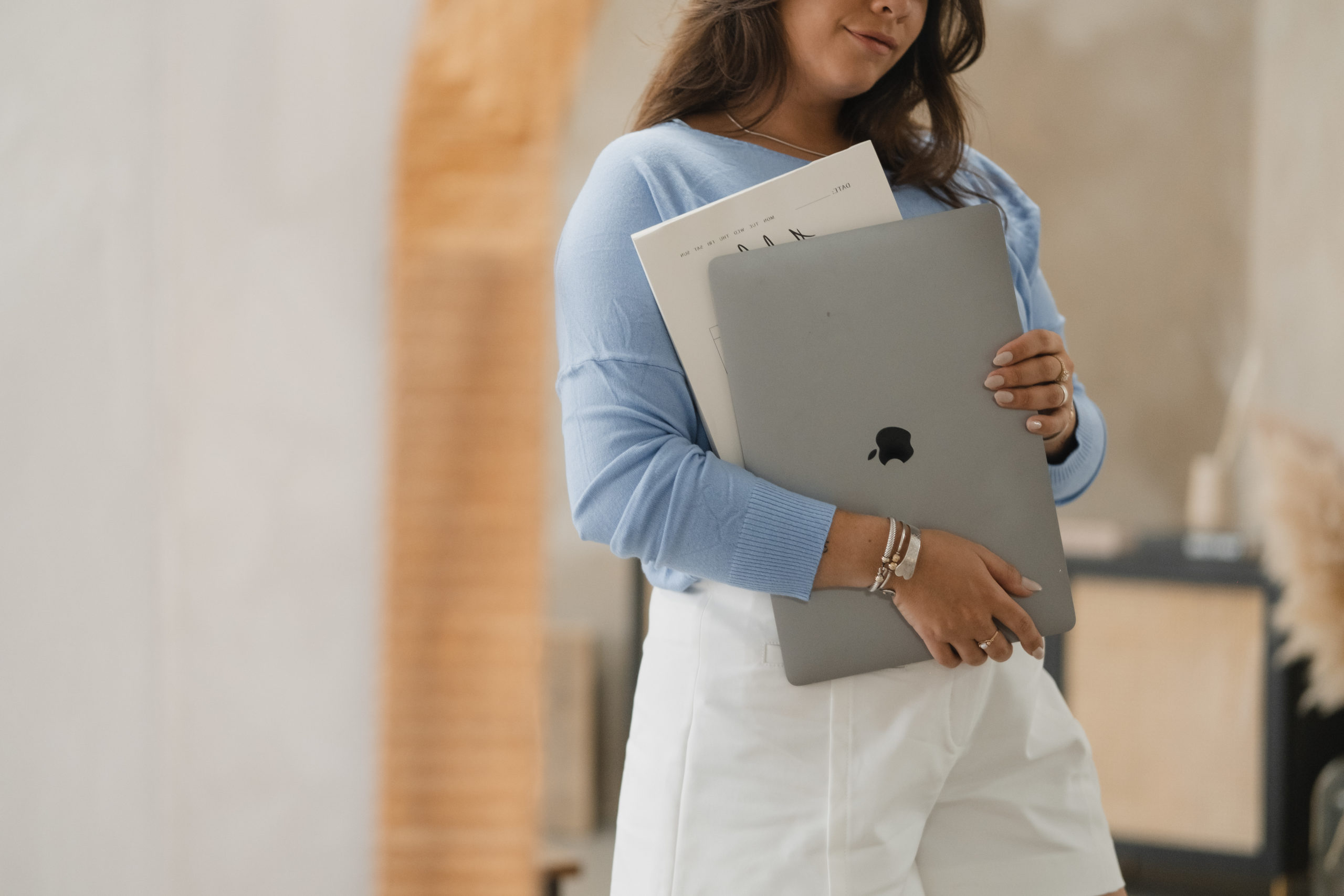 Image of Website Copywriter Sara Noel holding a laptop in a mirror.