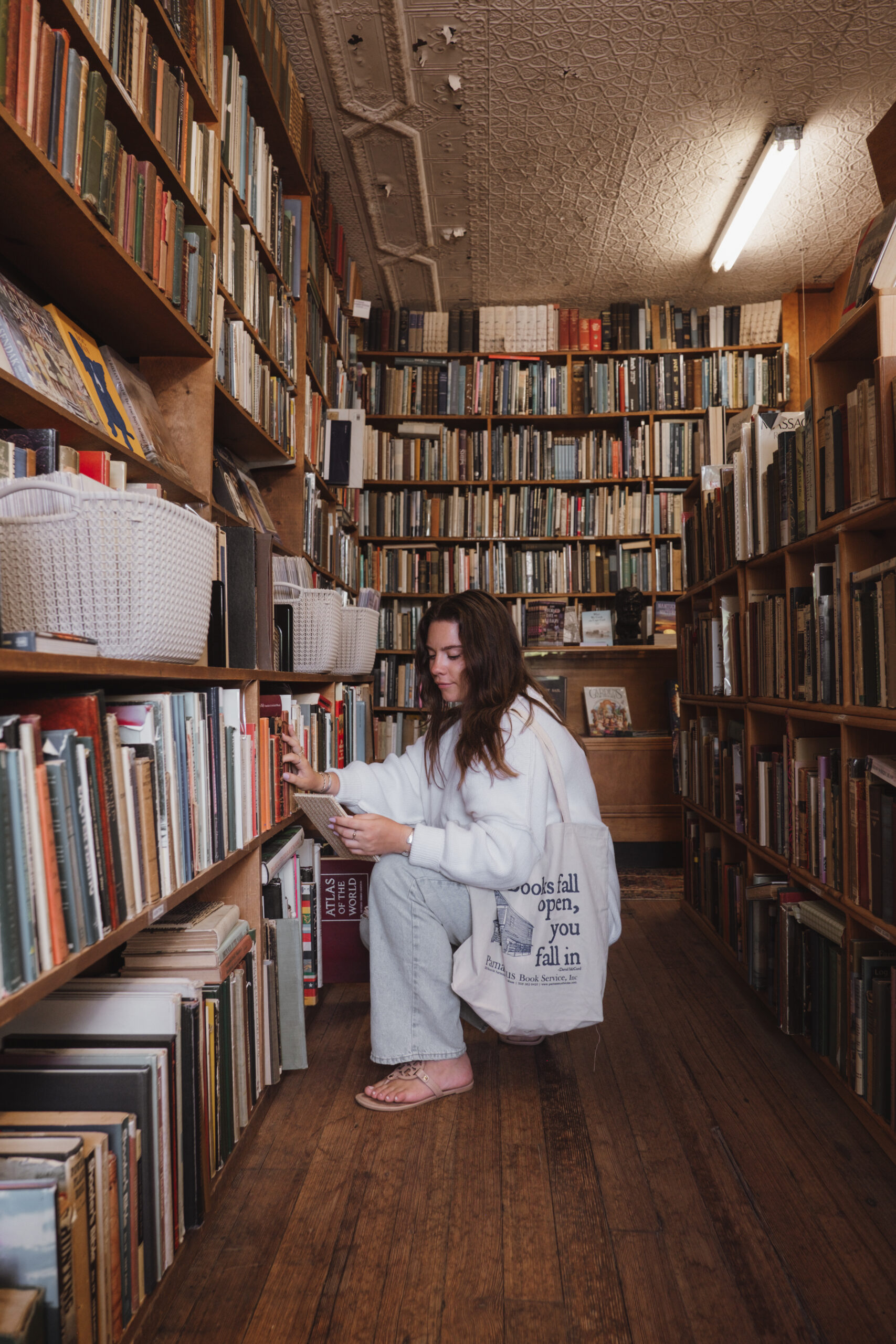 Website Copywriter Sara Noel looking for a book in a library